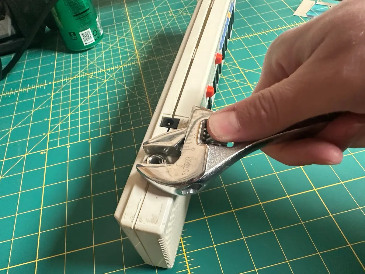 Using a crescent wrench to connect the nut to the 1/4" connector to hold it in place